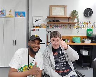 Two people smiling together at a table in a creative activity space
